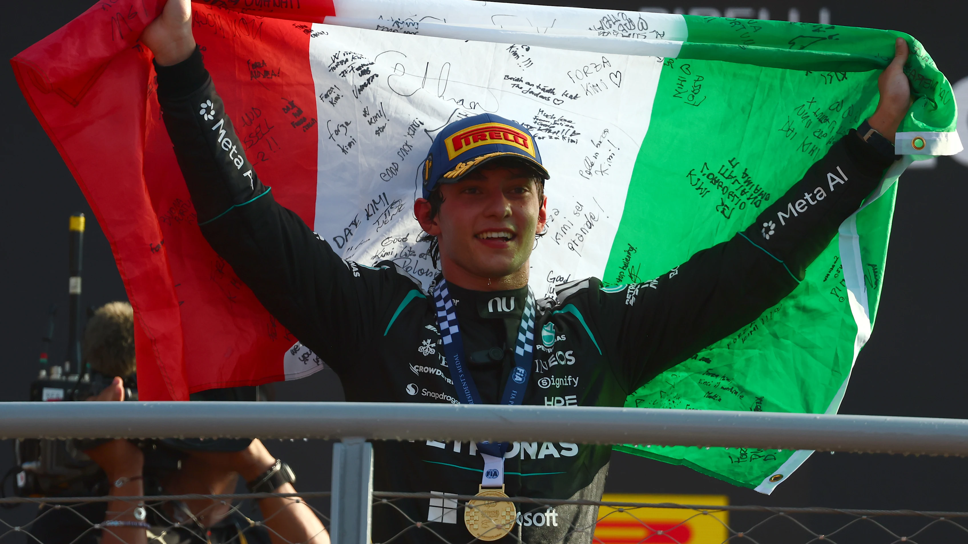 Kimi Antonelli holds an Italian flag after winning the 2026 Italian Grand Prix at Monza for Mercedes.